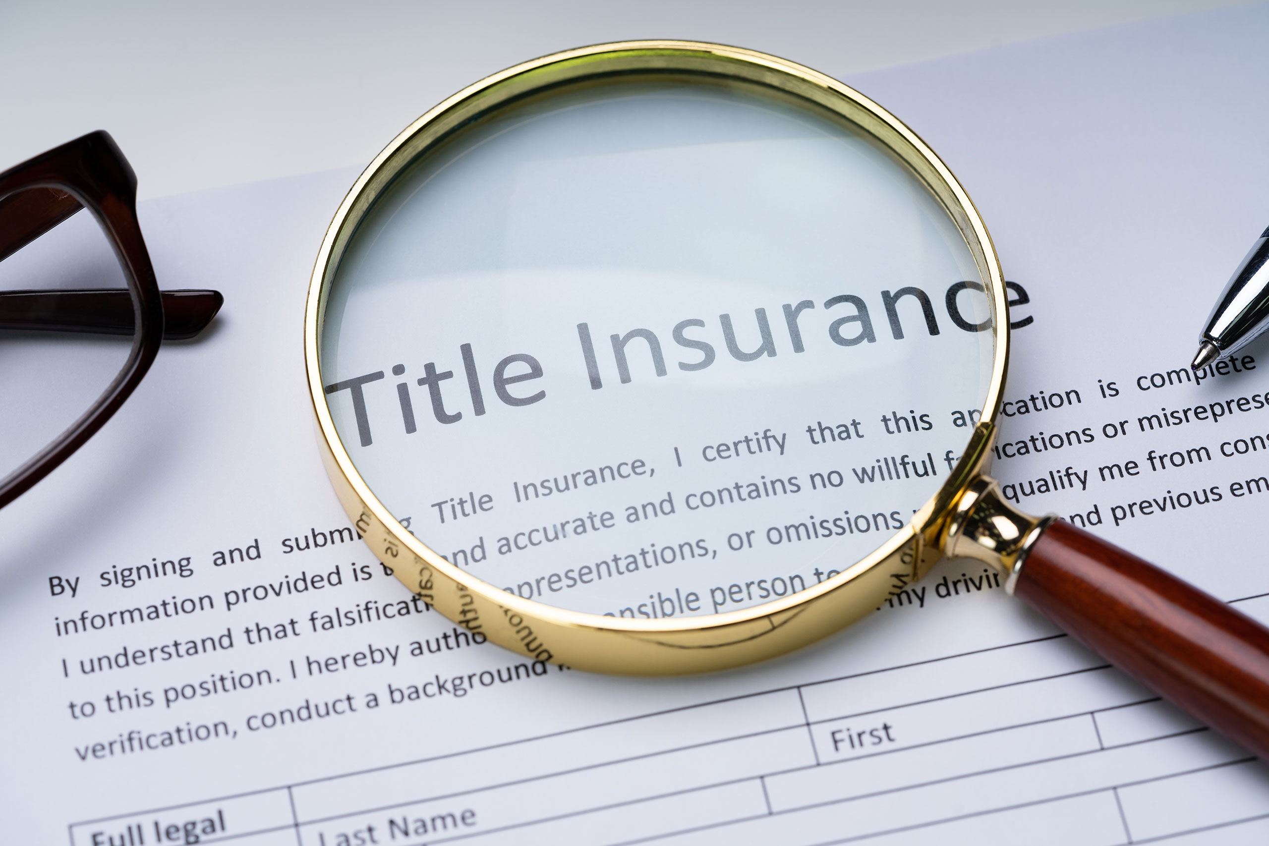 magnifying glass over title insurance form on table
